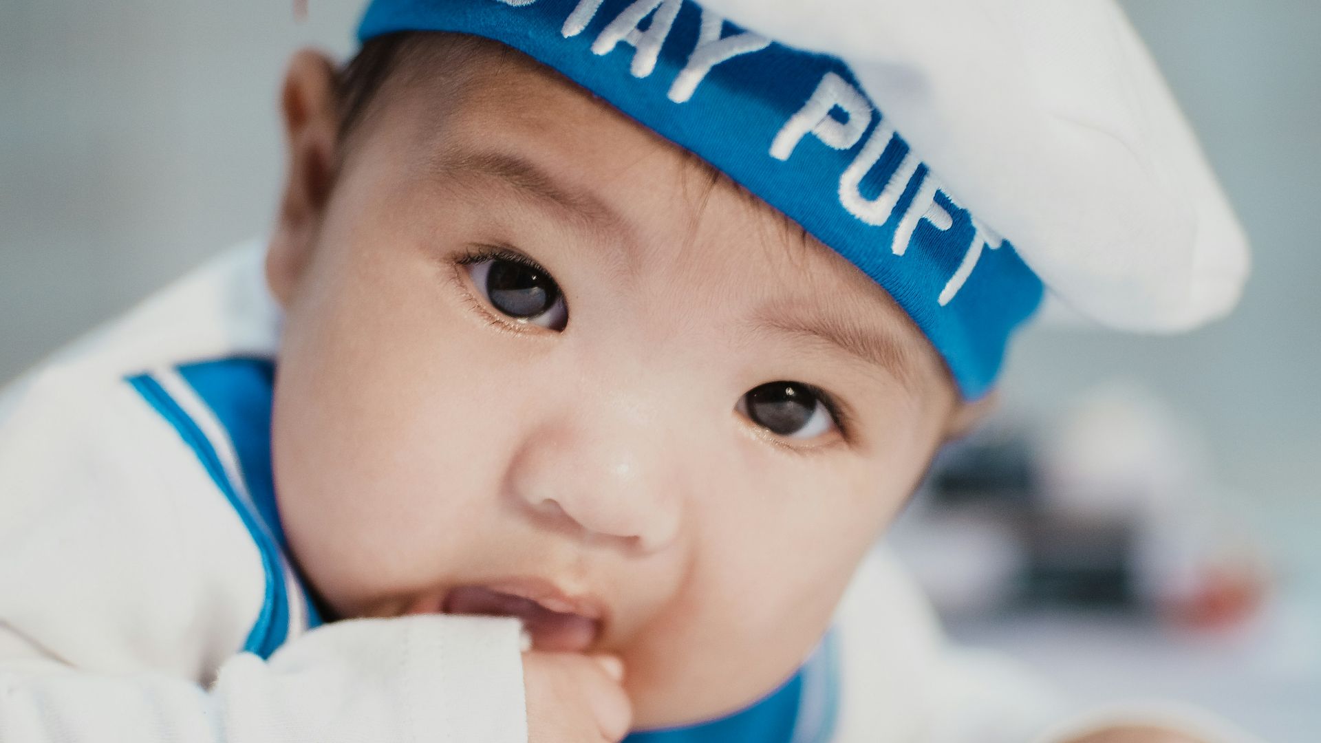 baby in white and blue navy costume